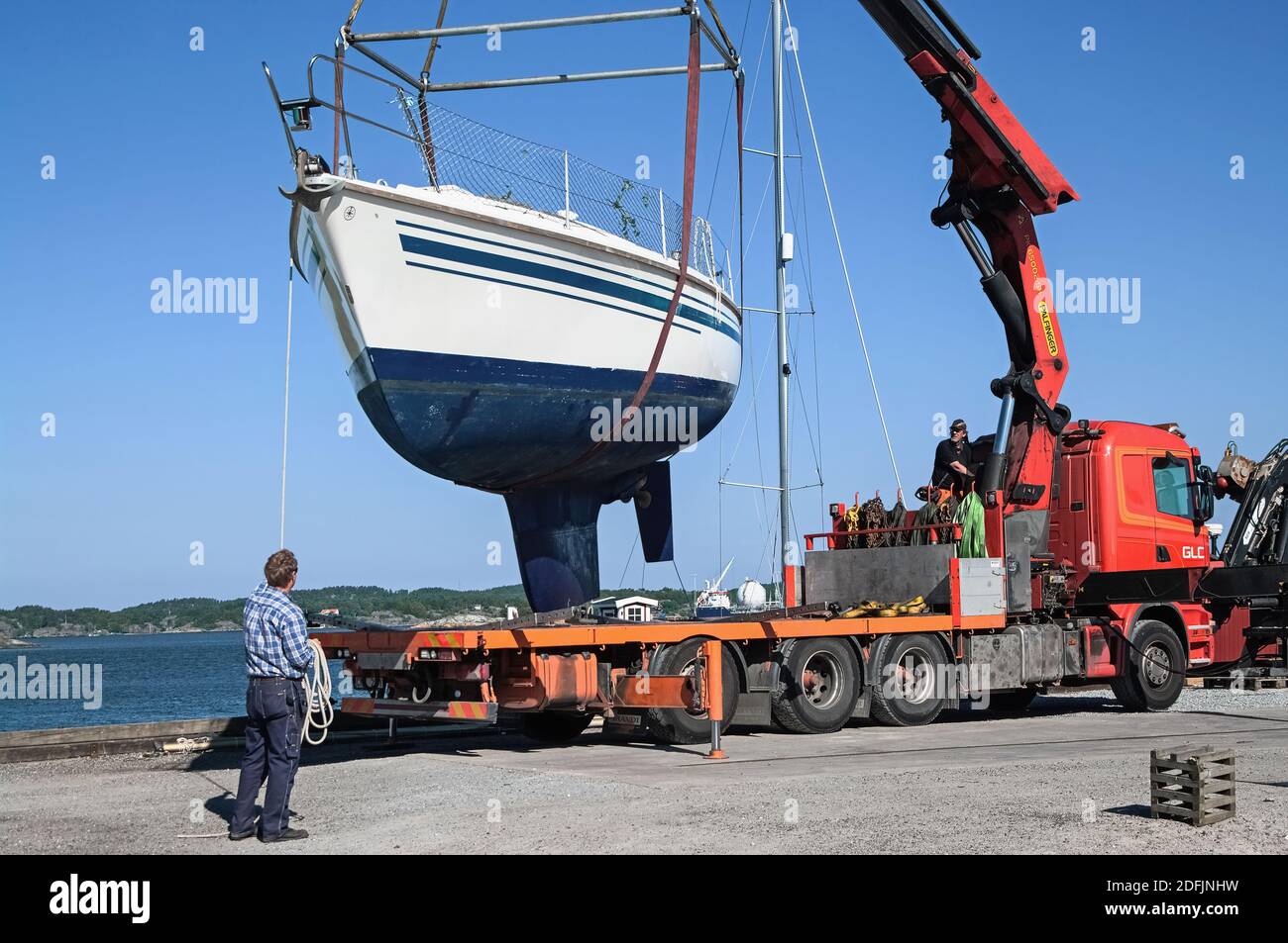 unloading a yacht from a truck with a manipulator Stock Photo