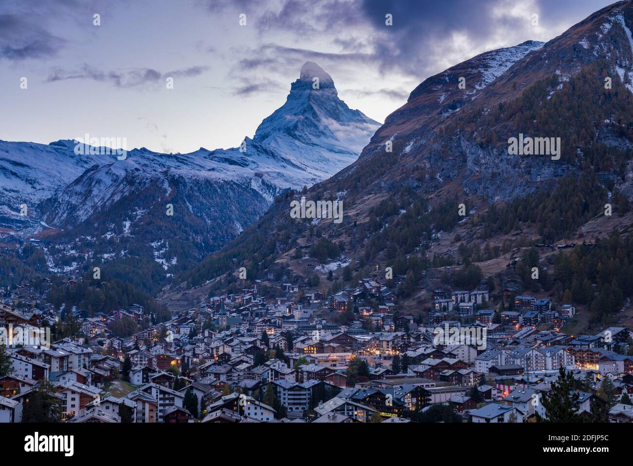 The Swiss village of Zermatt in Valais in autumn at dusk, with the Matterhorn and the Alpine mountain range in the background. Stock Photo