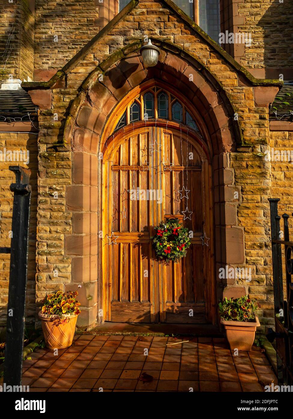 Front door to St John's United Reformed Church along Wilderspool Causeway in Warrington at Christmas Stock Photo