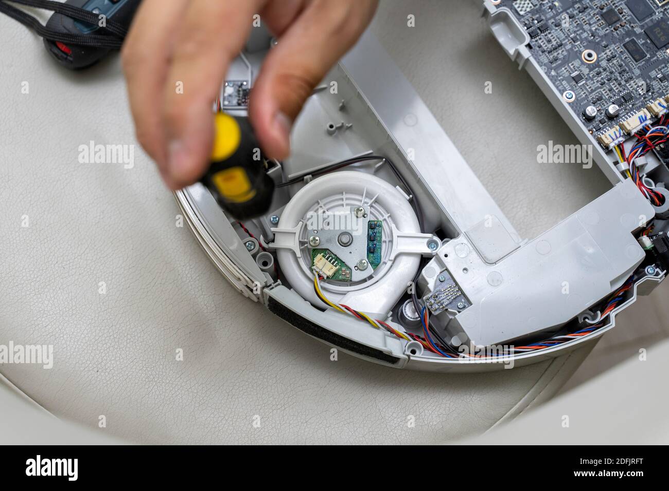 robot vacuum cleaner repair. A man is fixing robot vacuum cleaner during  open the cover showing an electronics circuit board in side the machine  Stock Photo - Alamy