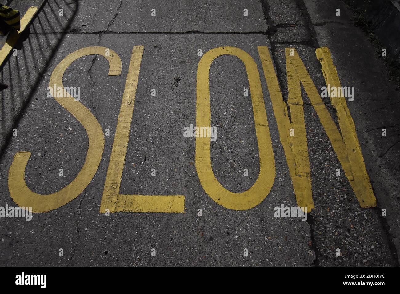 Yellow floor painted SLOW signage for drivers Stock Photo