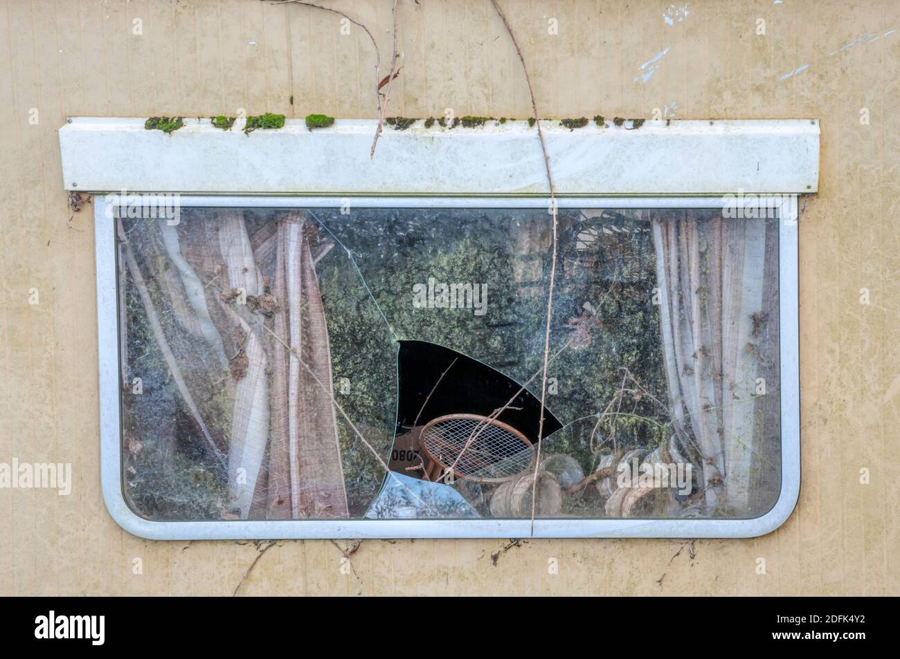 Broken window of an old derelict caravan. Stock Photo