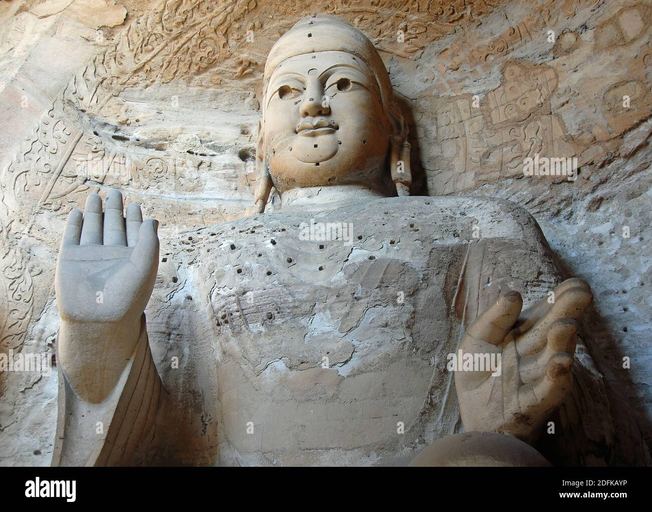 Yungang Grottoes near Datong in Shanxi Province, China. Large ancient statue of Buddha in a cave at Yungang. Landscape view from front Stock Photo