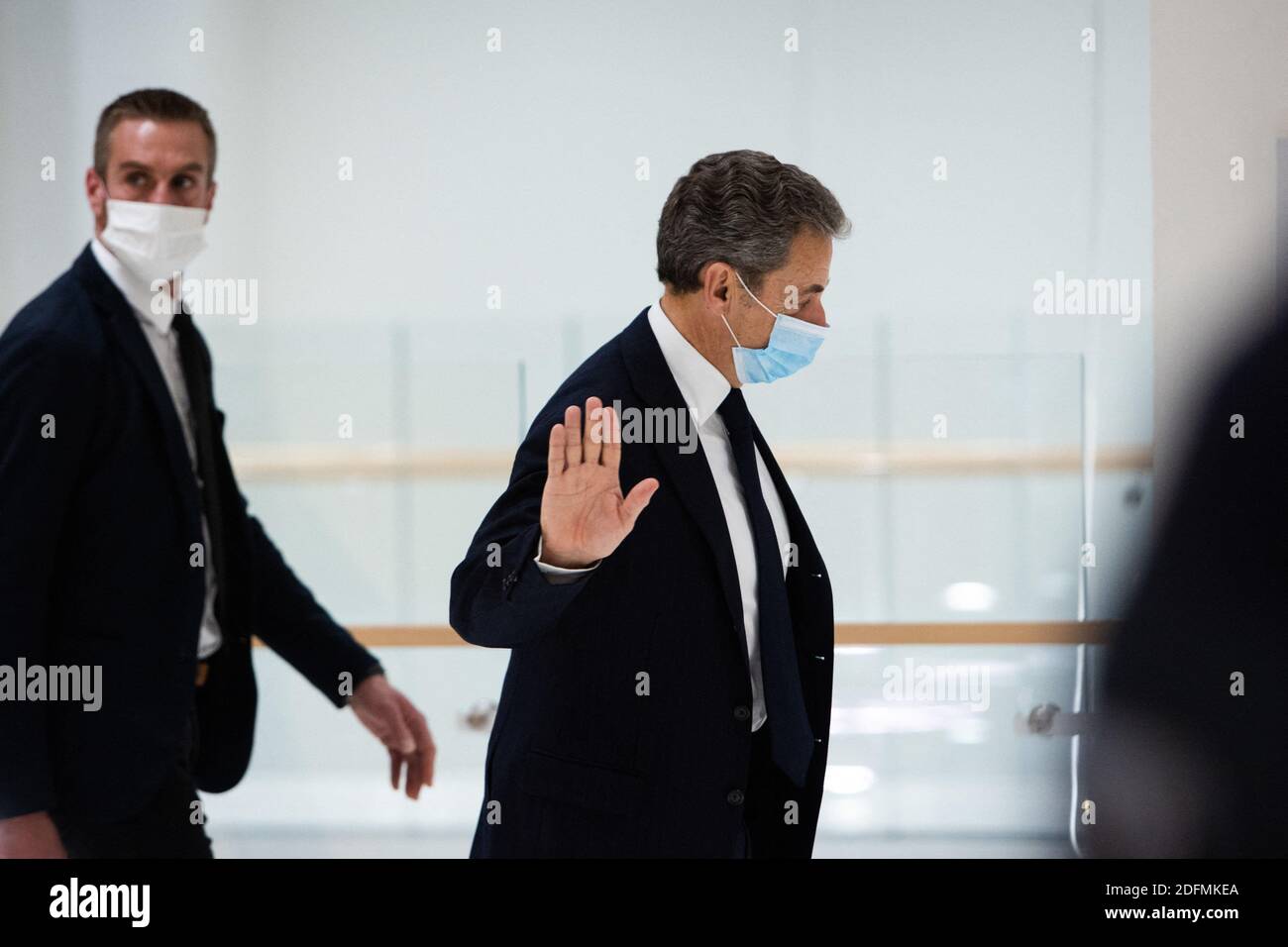Former French president Nicolas Sarkozy waves as he leaves the court room during a break of his trial for attempted bribery of a judge, in Paris on November 23, 2020. Sarkozy, 65, a rightwing politician who led France between 2007 and 2012, has repeatedly denied the accusations of corruption and influence peddling for allegedly trying to bribe a judge for information in a case known as the 'bugging affair'. The prosecution alleges Sarkozy and his lawyer, Thierry Herzog, attempted to bribe a senior magistrate, Gilbert Azibert, 74, to hand over secret information from a separate investigation ag Stock Photo