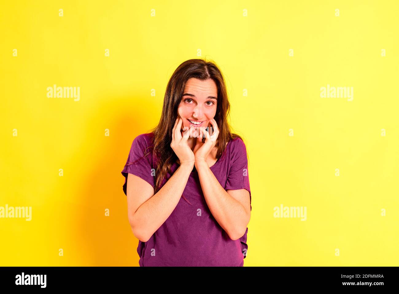 Adorable young woman with thoughtful, pensive gesture dressed casual, isolated on studio background. Stock Photo
