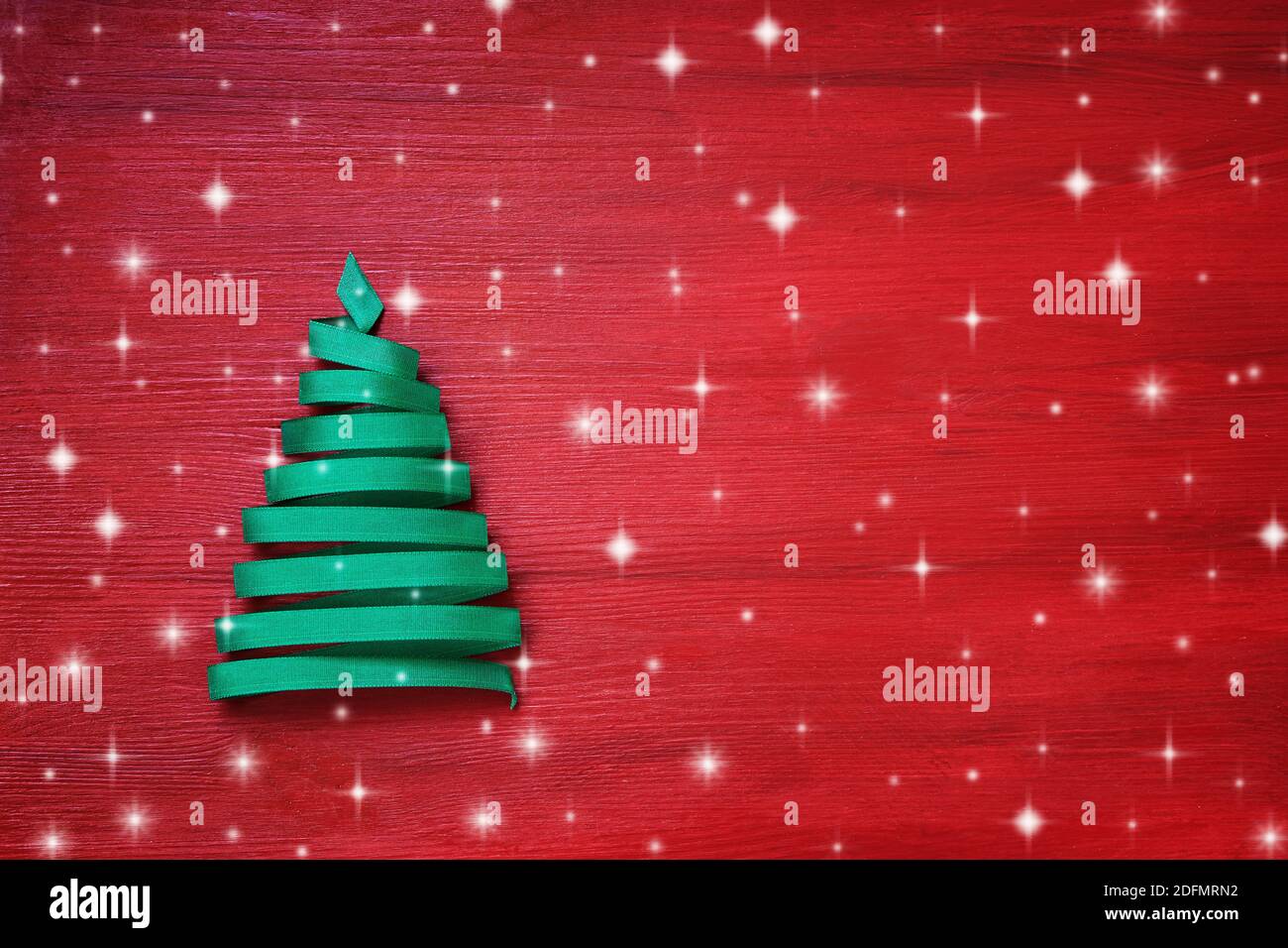 Christmas tree made from the ribbon on a red background. Copy space ...