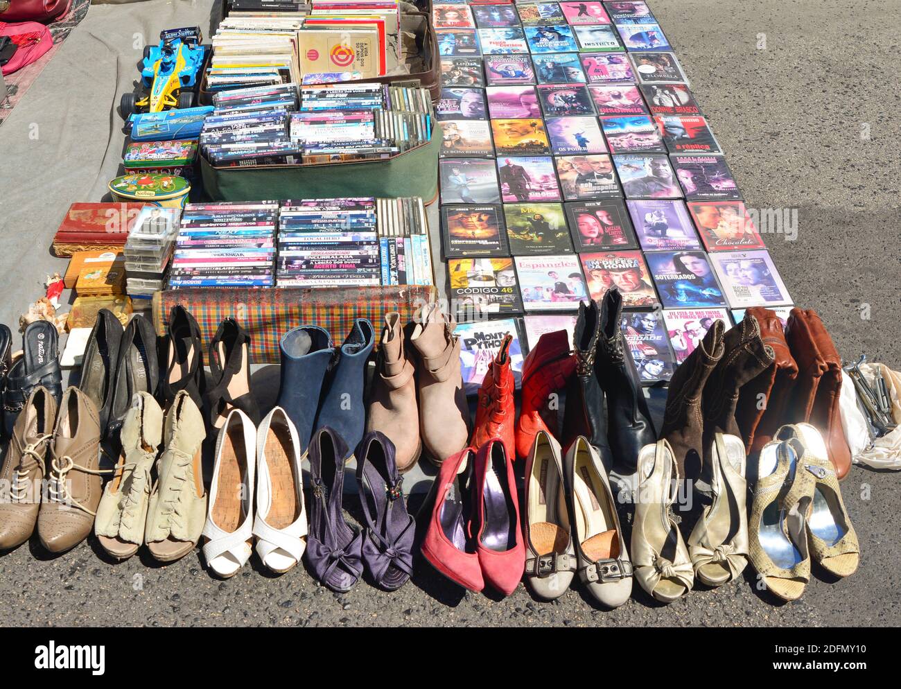Lisbon, Portugal - August 05, 2017: DVD movie collection and heap of old used shoes of women at the flea market Stock Photo