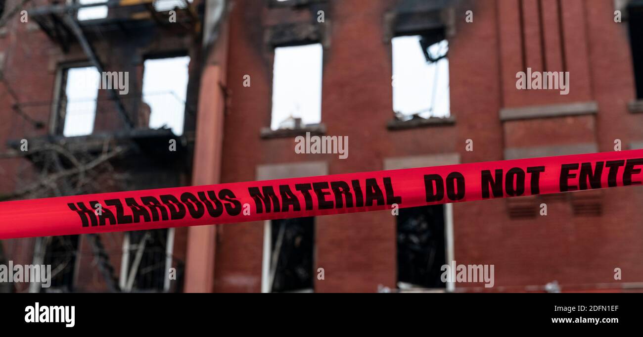 Firefighters install warning hazardous tape around fire scene in the ...