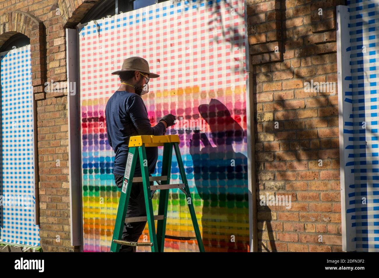 A man creates a colorful pattern while boarding up his business in downtown Minneapolis during the George Floyd riots Stock Photo