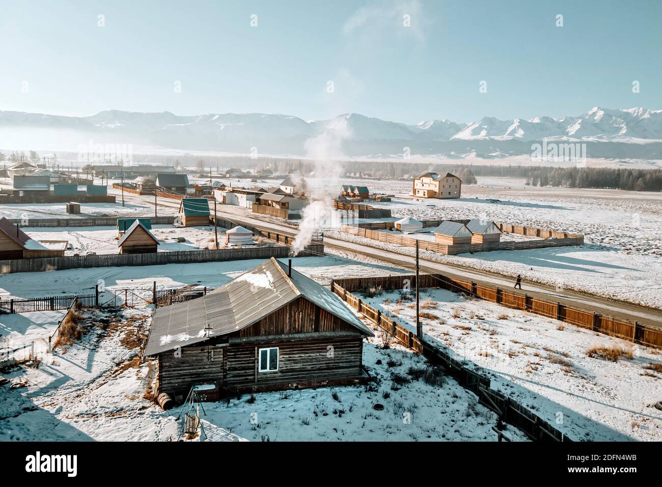 Russian village. Wooden huts with smoke from chimneys in the winter ...