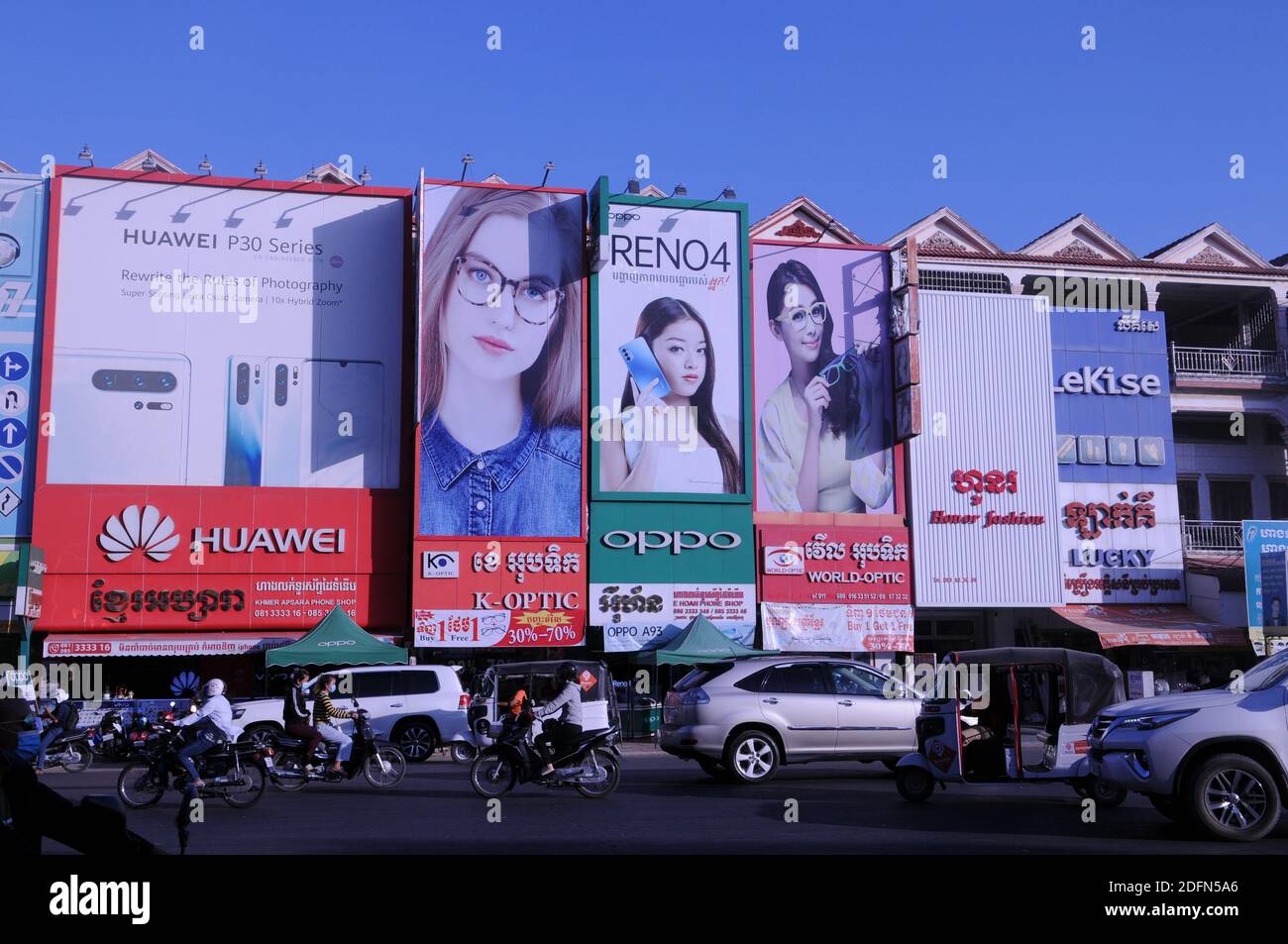 giant billboards for smartphone shops & optical shops w/ traffic below. Steung Meanchey, Phnom