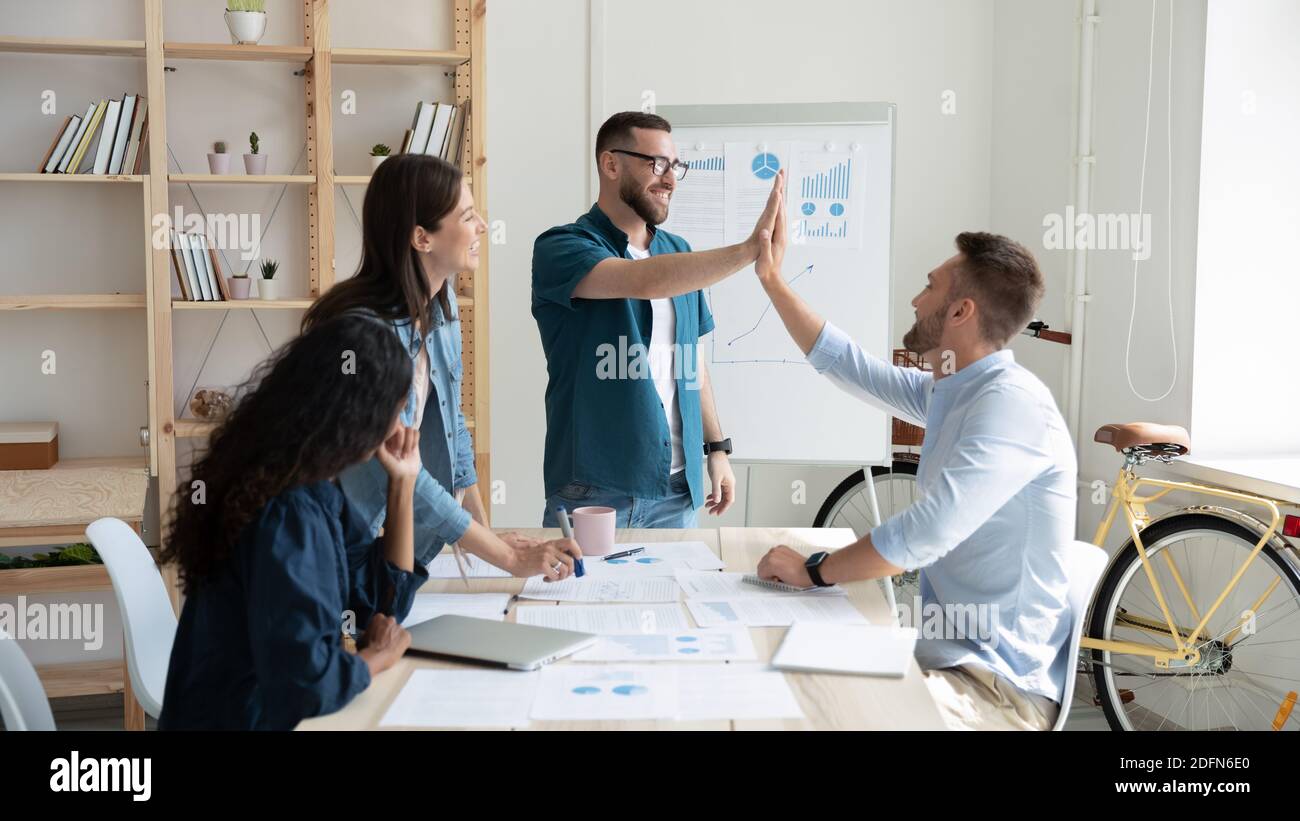 Banner view of male colleagues give high five Stock Photo - Alamy