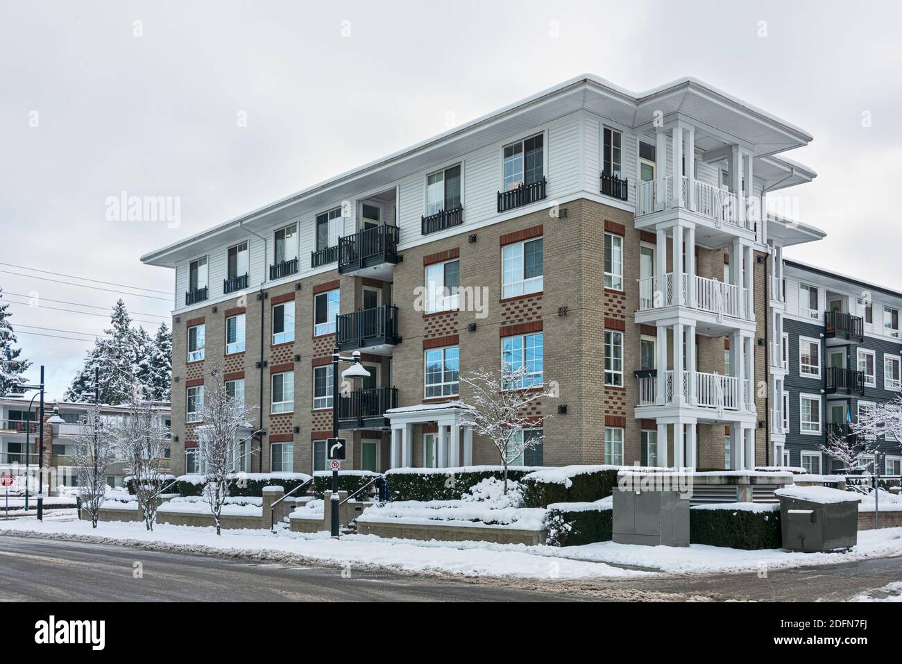 Residential low-rise building on winter day with white sky background ...