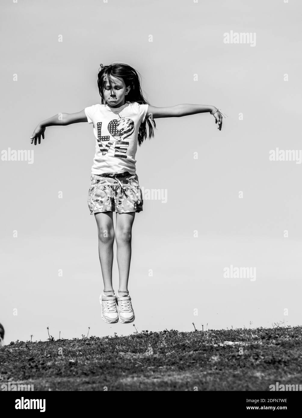 girl jumping in the air at a park Stock Photo
