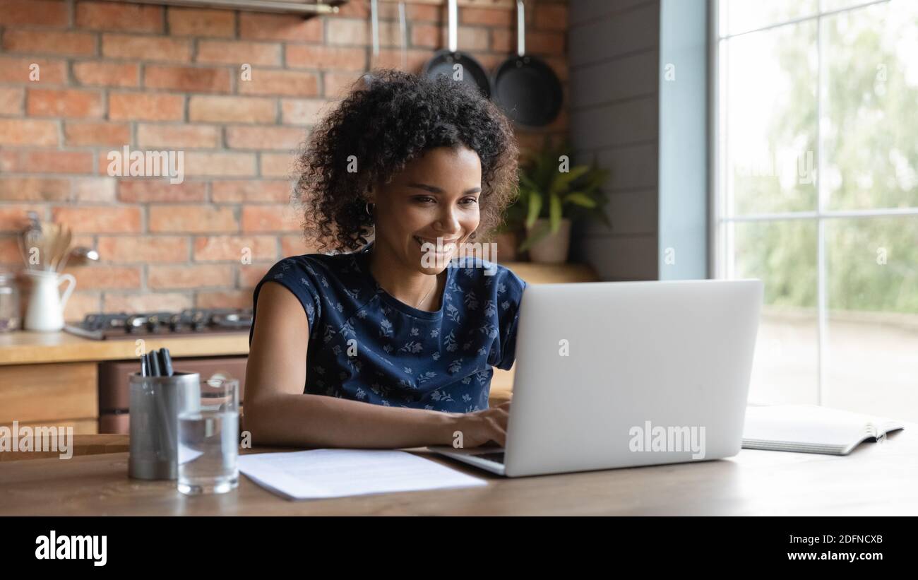 Happy young african ethnicity multiracial businesswoman working on computer. Stock Photo