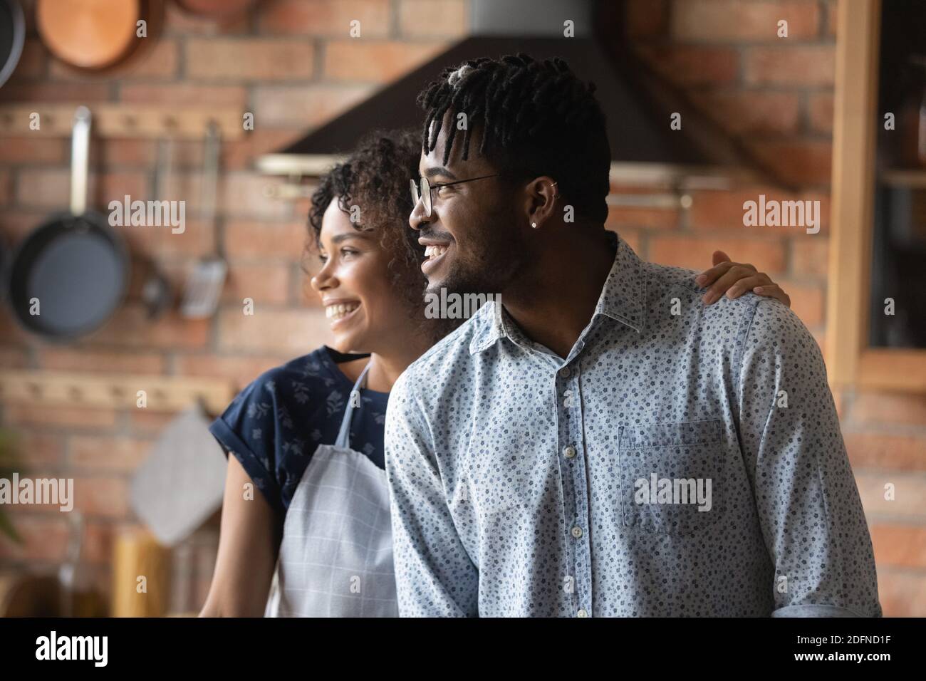 Happy young bonding african american couple dreaming indoors. Stock Photo
