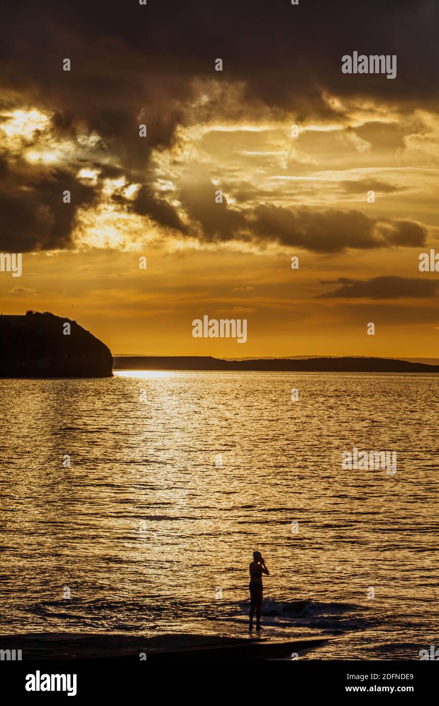 The setting sun reflecting sunlight onto a calm sea Stock Photo - Alamy