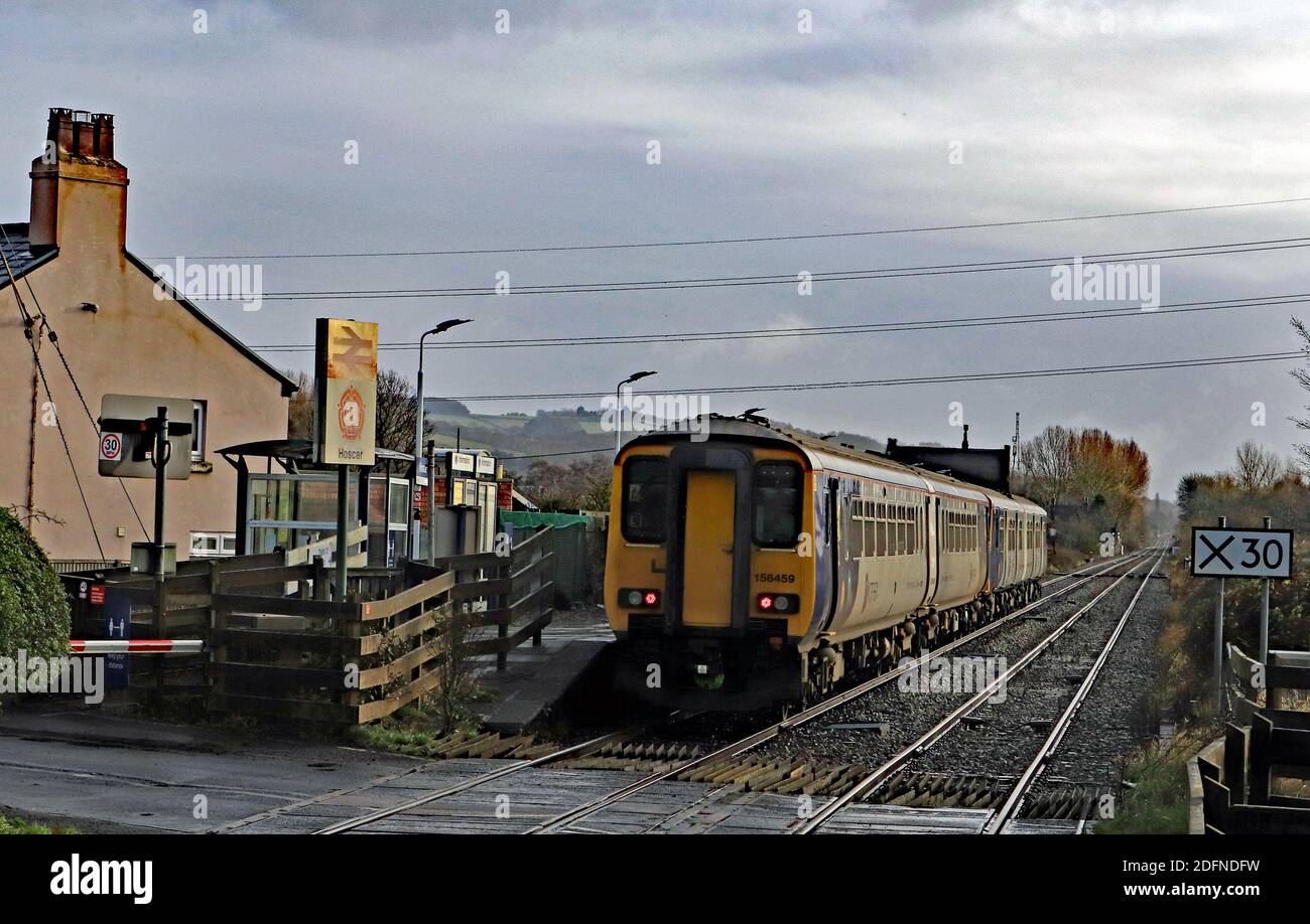 A Northern diesel train hurries through the rural station at Hoscar between Burscough and Parbold with a service from Southport to Stalybridge. Stock Photo