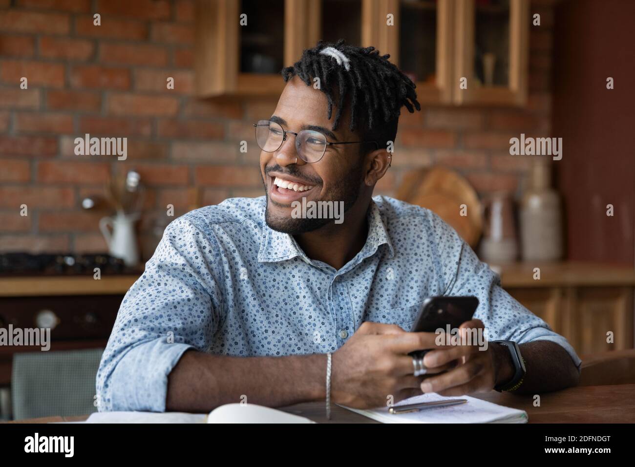 Happy young african ethnicity man using smartphone. Stock Photo