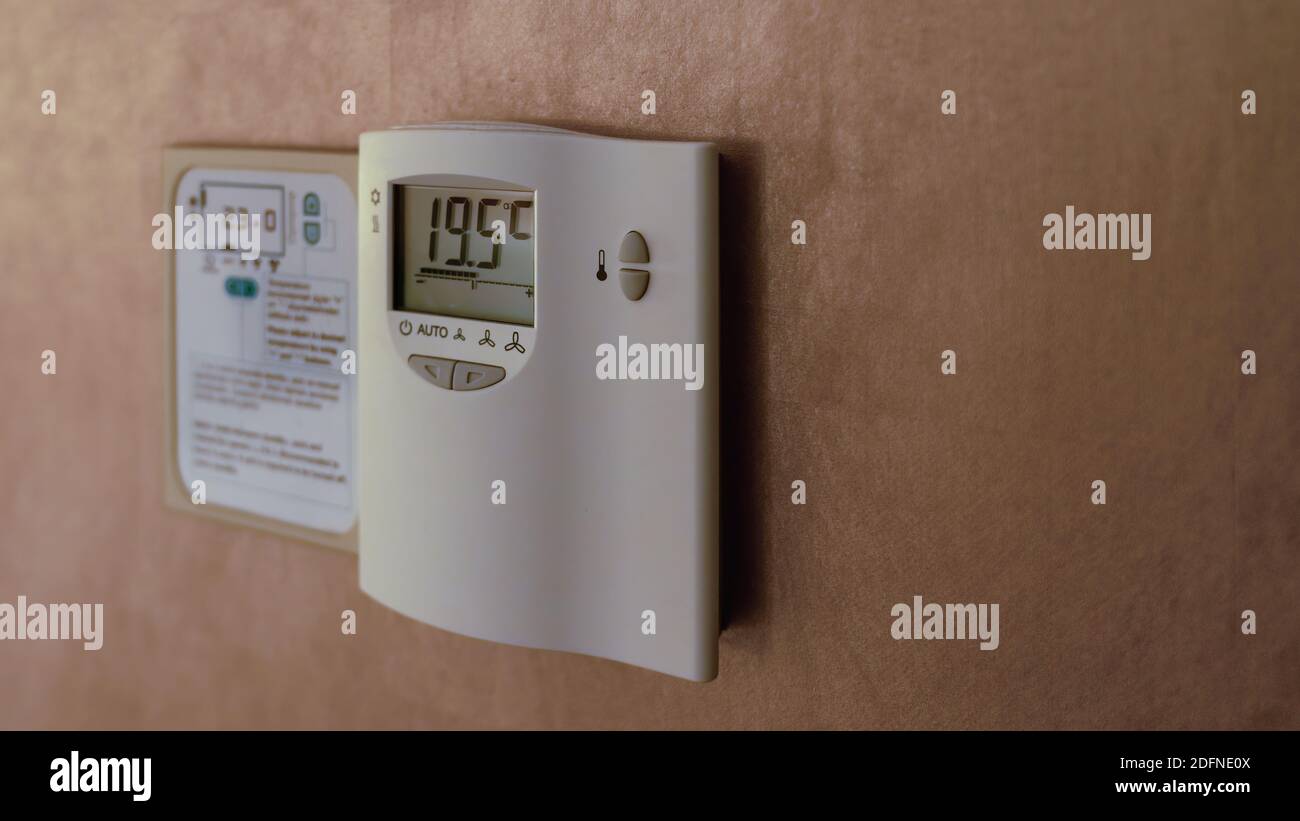 Digital Thermostat on the wall. Adjusting and setting thermostat to