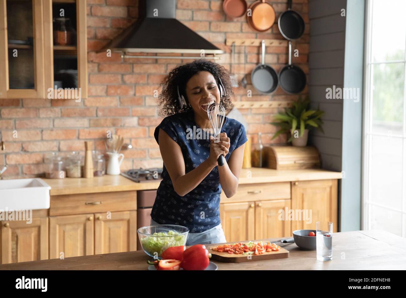 Woman in hair curlers taking funny selfie on mobile while cooking in the  kitchen Stock Photo - Alamy