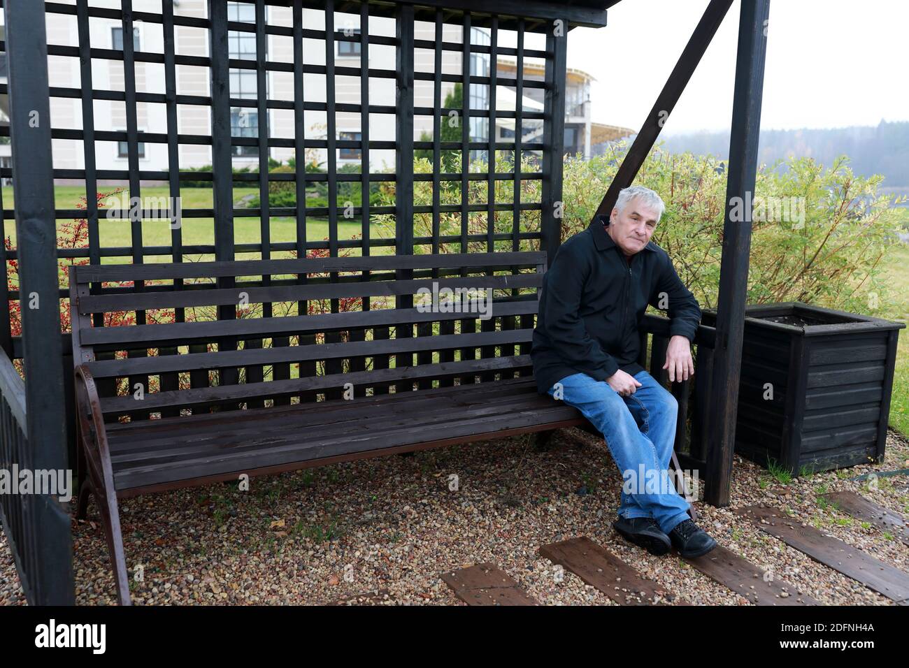 Elderly man sitting on bench in autumn Stock Photo - Alamy
