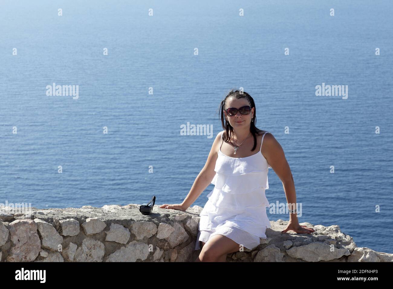 Woman sitting wall sea sky day hi-res stock photography and images - Alamy