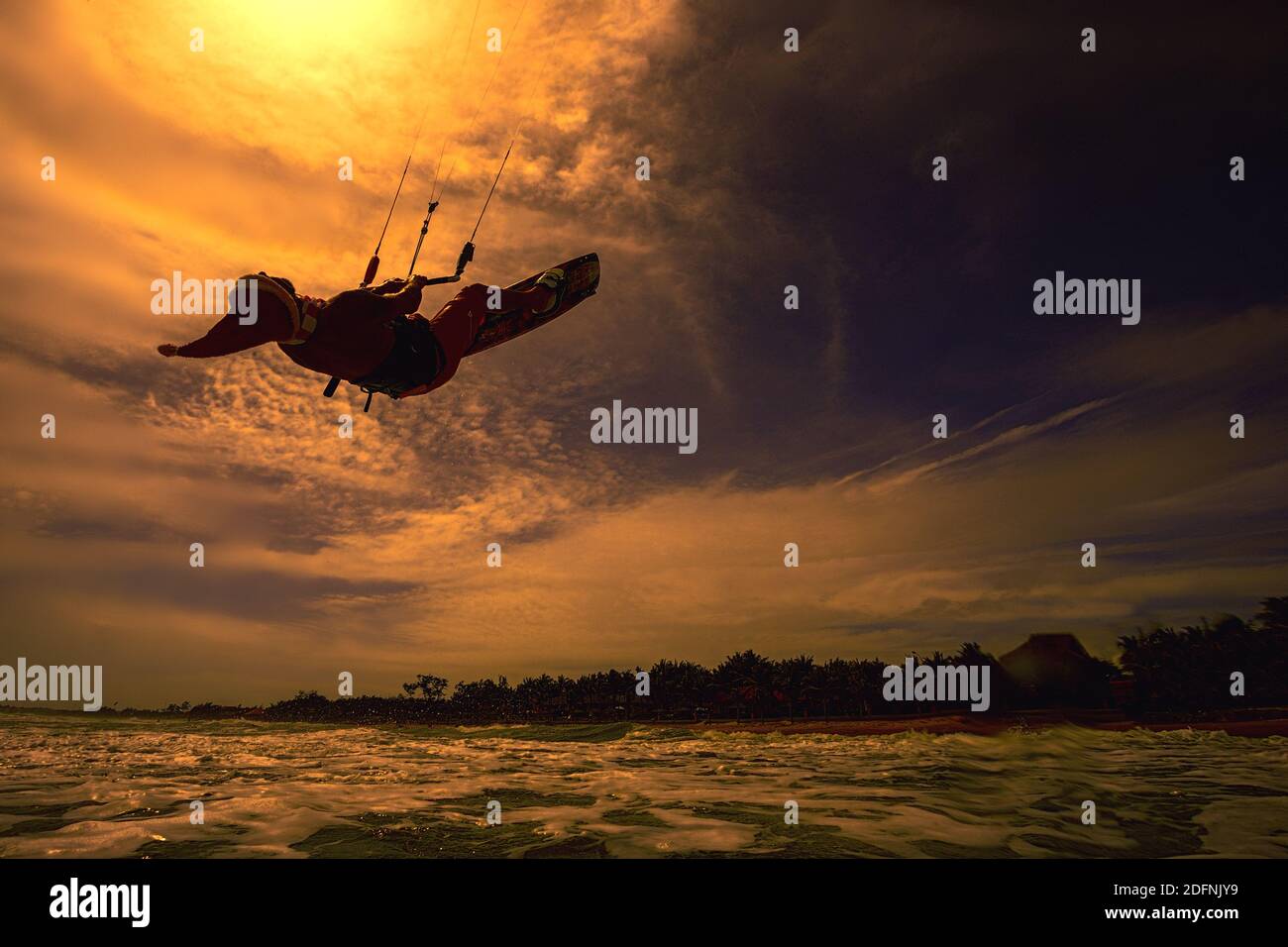 Santa Claus professional kitesurfer rides sea waves and flying over water Stock Photo