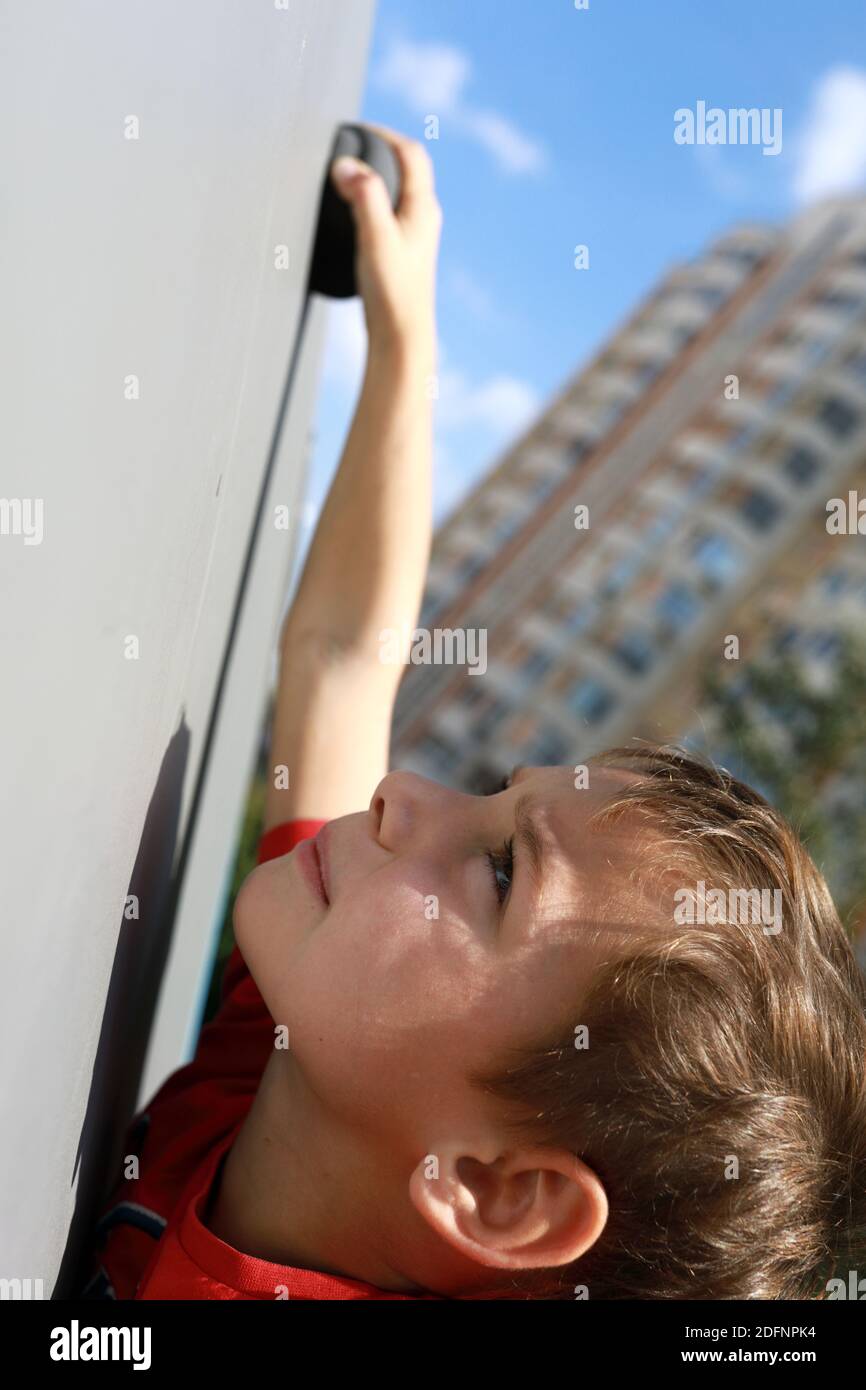 Kid climbs the wall on the playground Stock Photo Alamy