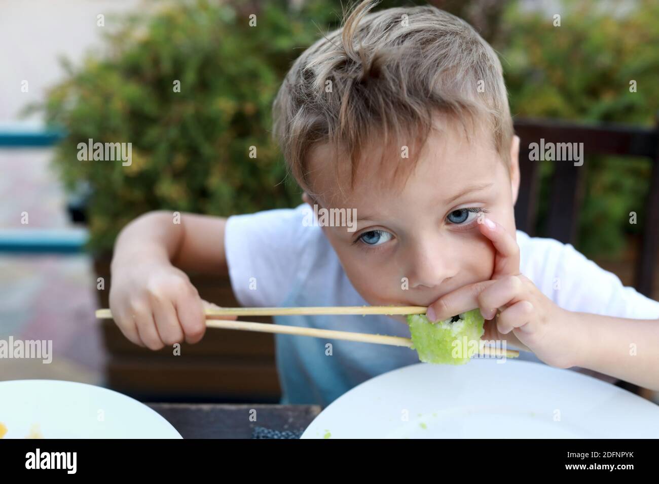 Child eating sushi at table in restaurant Stock Photo - Alamy