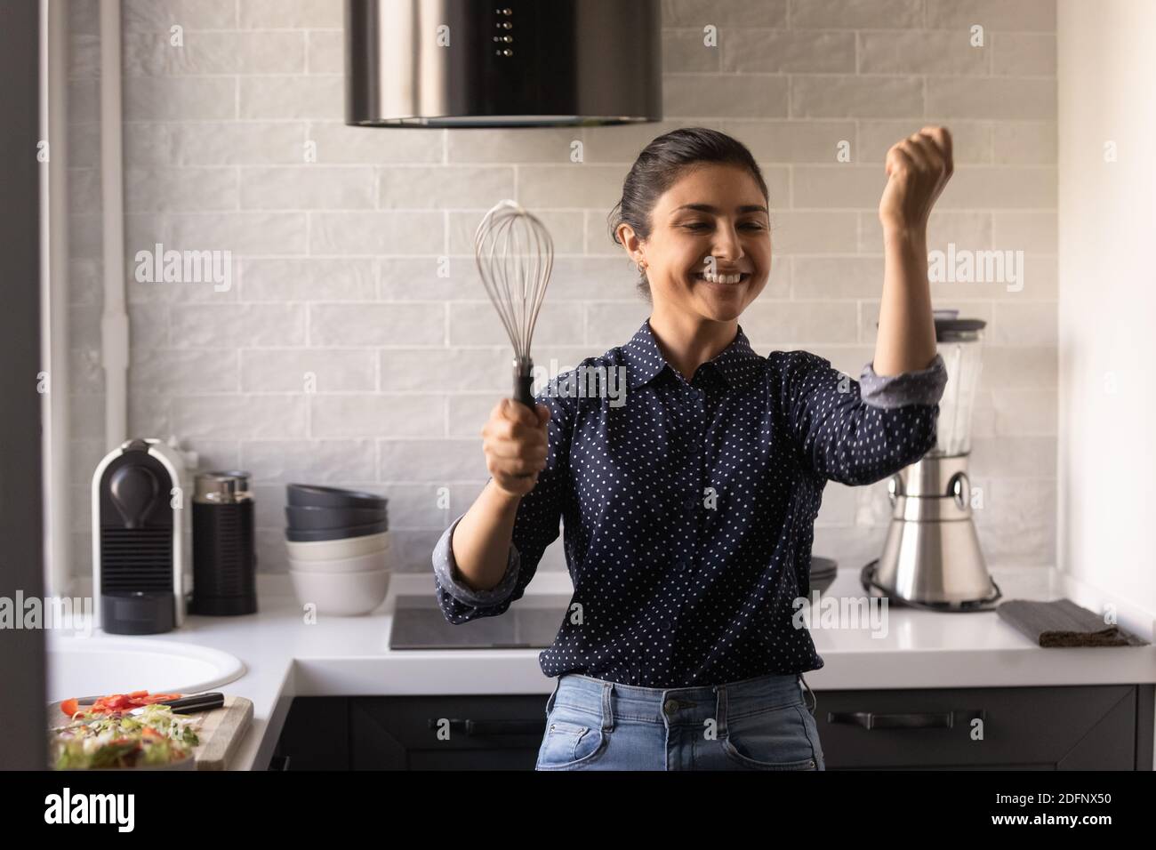 Funny young housewife cooking in kitchen Stock Photo - Alamy