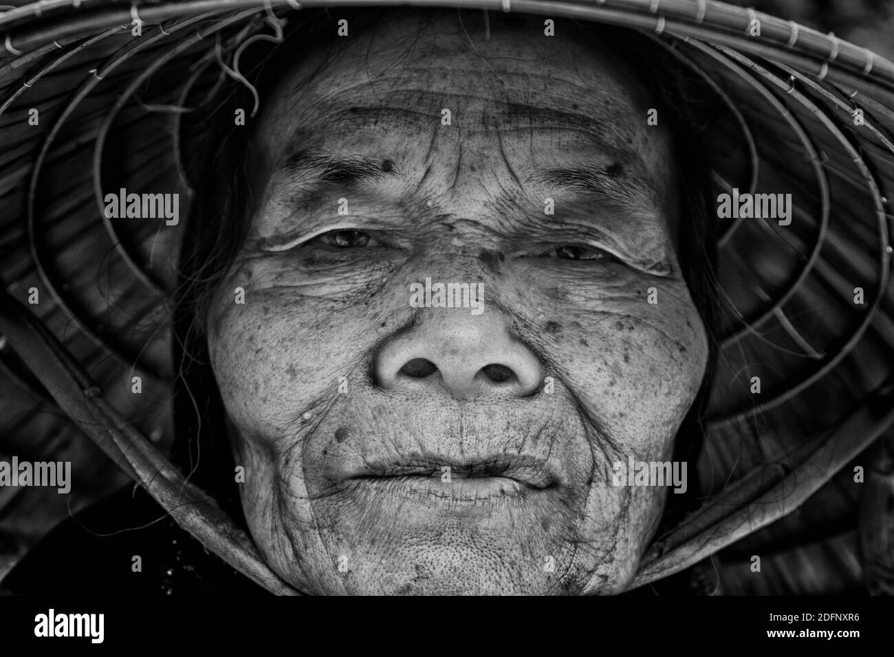 Vietnamese elderly woman selling incense at the entrance of a temple | VIETNAM | SAPA Stock Photo