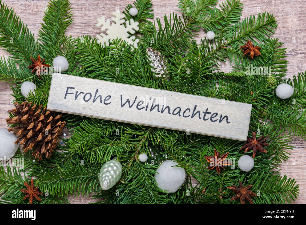 Weihnachtsdekoration mit grünen tannenzweigen und einem Schild 'Frohe Weihnachten' Stock Photo