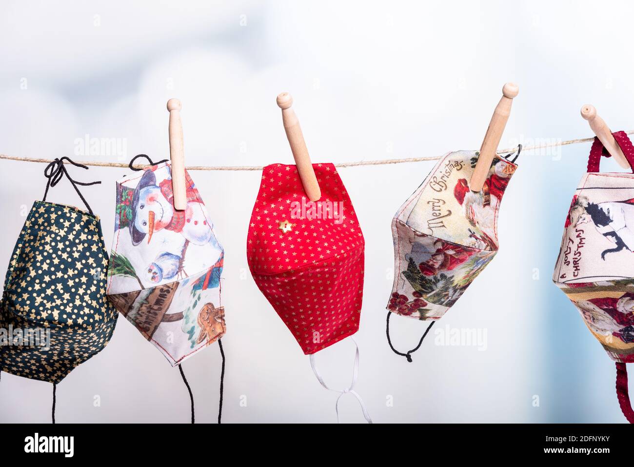 Bunte Corona Masken auf einer Wäscheleine in der Vorweihnachtszeit Stock Photo