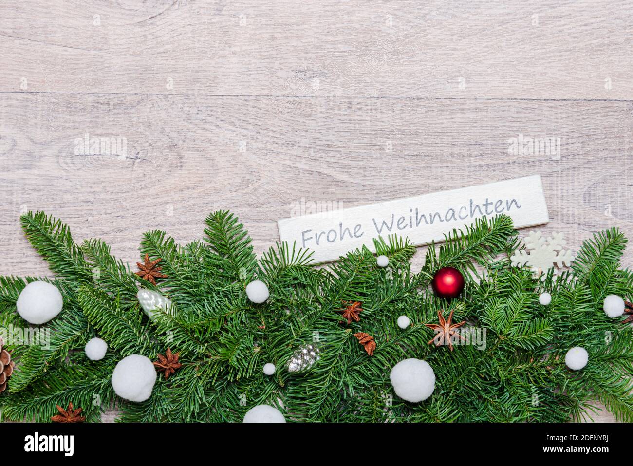 Weihnachtsdekoration mit grünen Tannenzweigen, Corona Alltagsmasken und einem Schild 'Frohe Weihnachten' Stock Photo