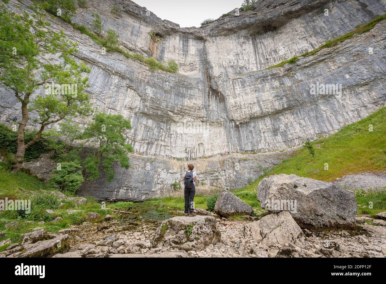 A person looks up at Malham Cove, Yorkshire Dales National Park, Yorkshire, UK Stock Photo