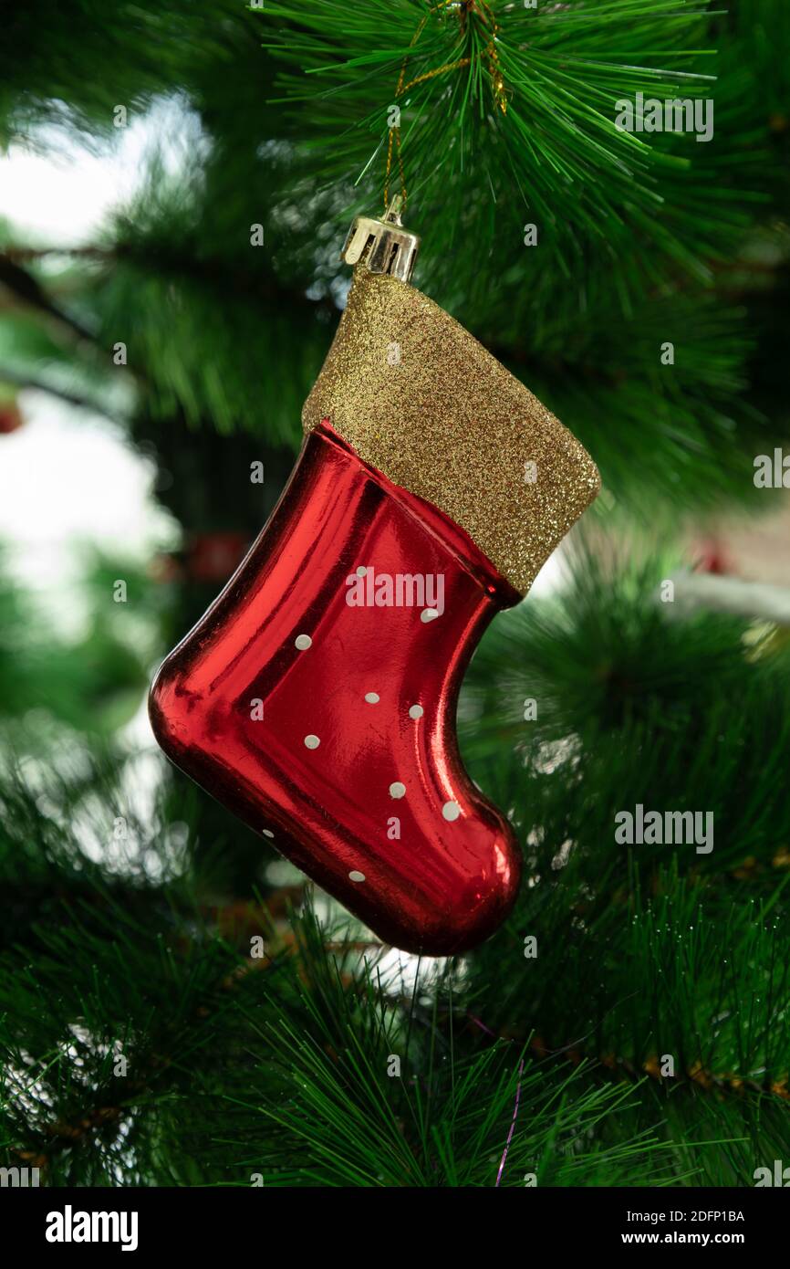 A beautiful red santa boot tree hanging, adorning a Christmas tree. Stock Photo