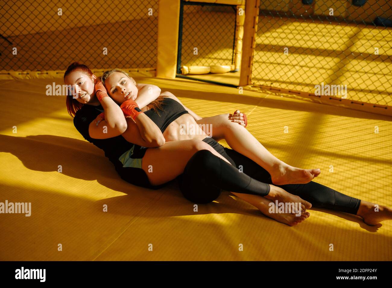 Female MMA fighter performs painful choke hold Stock Photo