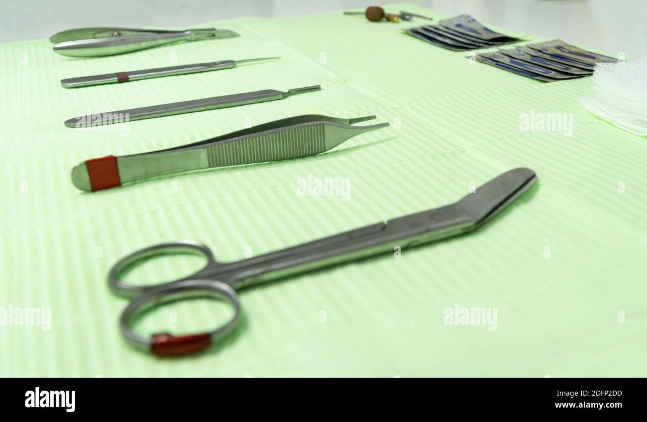 Close up of podiatry material on a work table. We can see scissors and tweezers in the foreground and the rest of the tools in the background Stock Photo