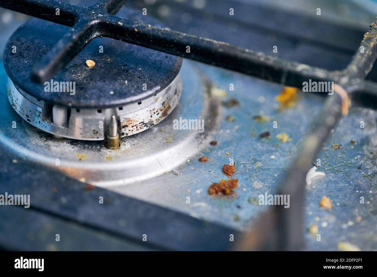 Dirty gas stove top with food leftovers. Unclean steel kitchen cooktop