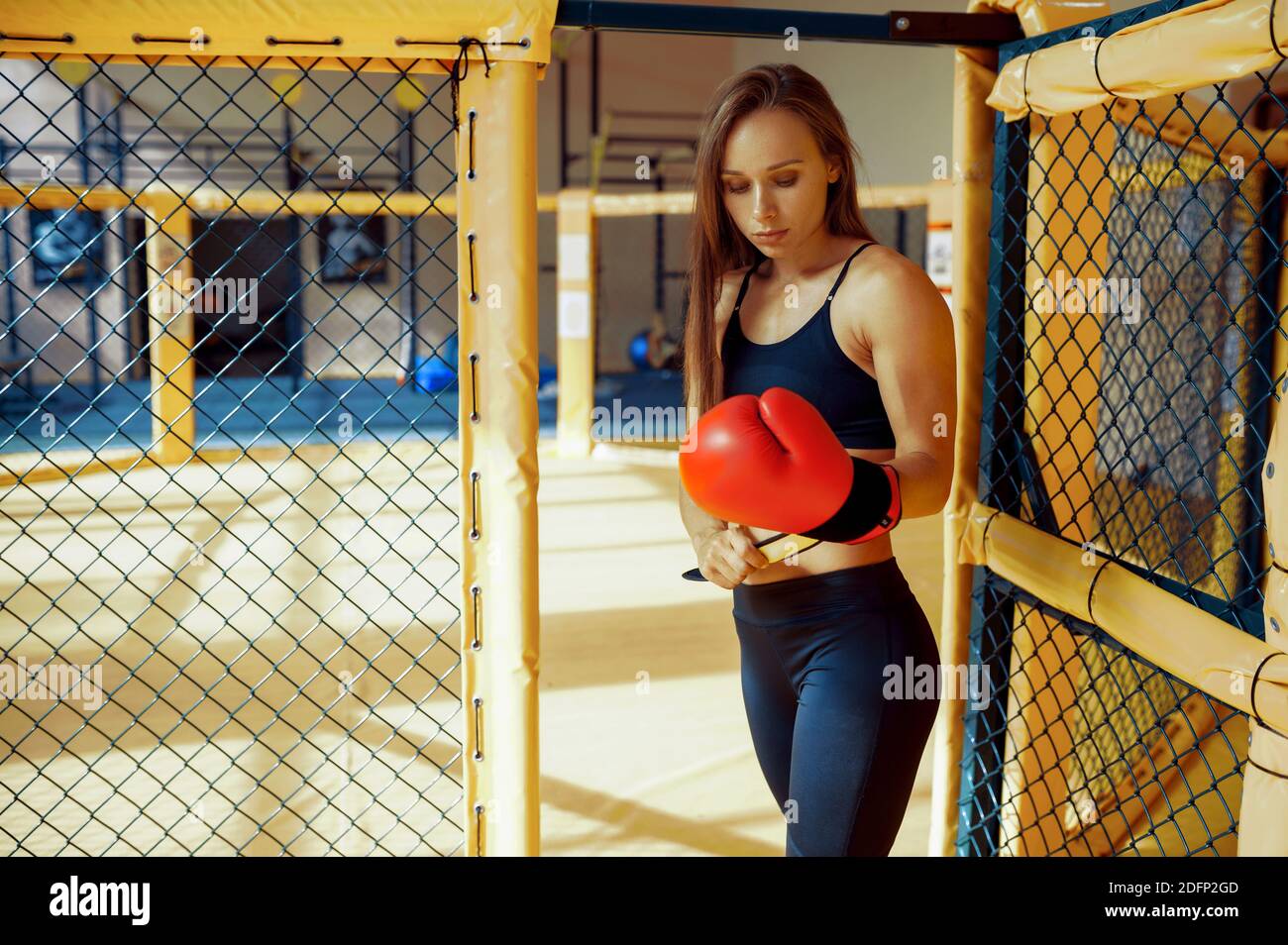 Female MMA fighter in boxing gloves on training Stock Photo