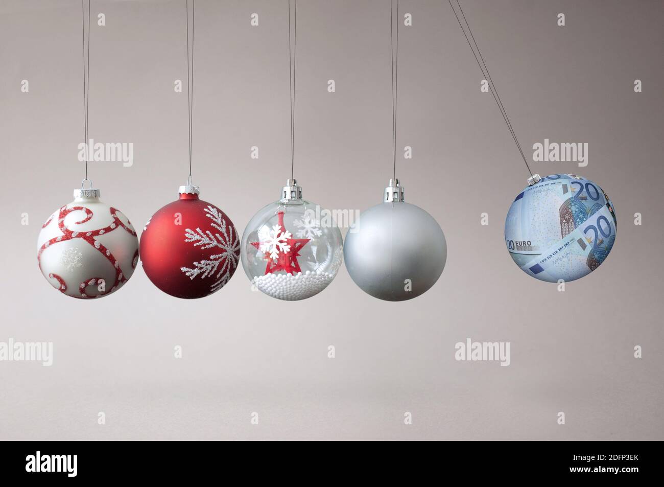 Euros bauble colliding into christmas ornaments, seasonal shopping budget and balancing finances concept Stock Photo