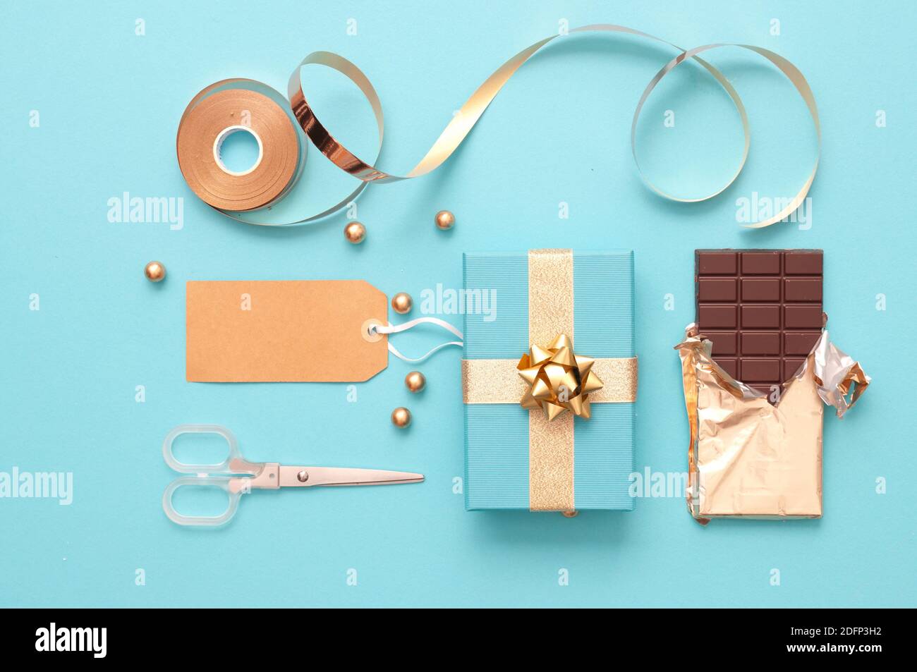 Christmas gift boxes wrapped in gold with baubles, and wrapping