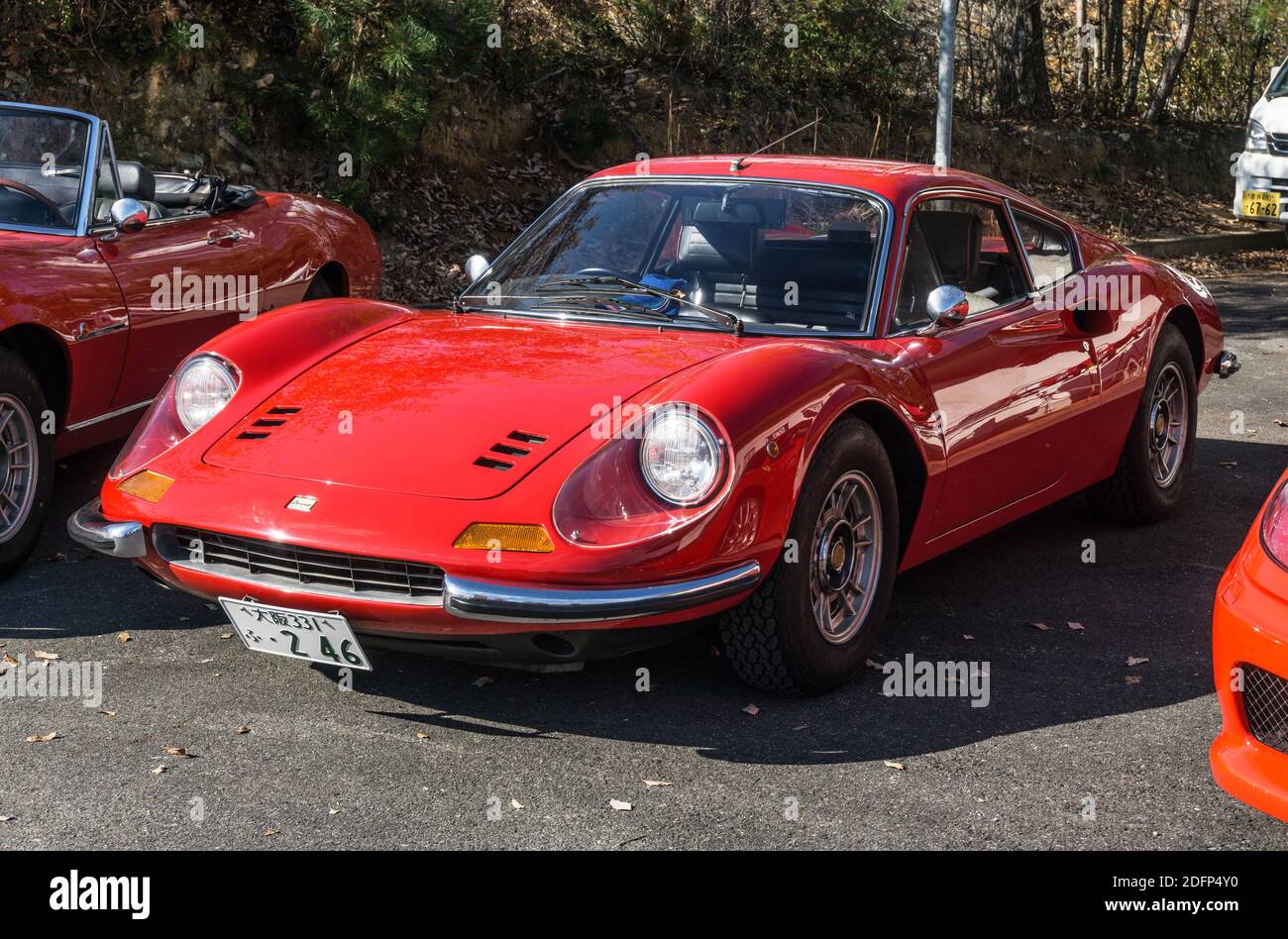 A red 1970s Ferrari Dino 246 GT small sports car parked outside in sunshine in Kyoto, Japan Stock Photo