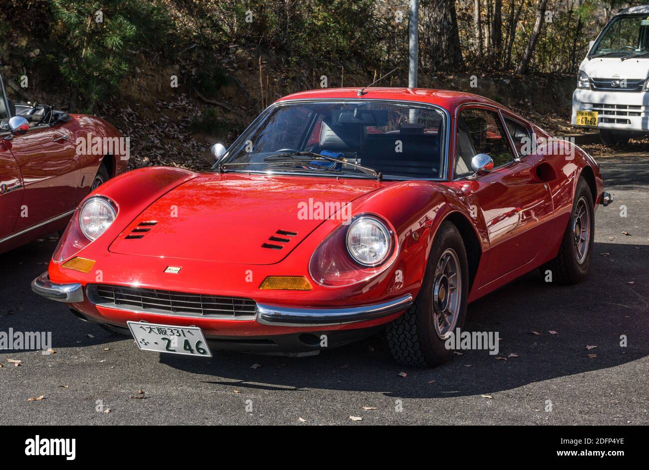 A red 1970s Ferrari Dino 246 GT small sports car parked outside in sunshine in Kyoto, Japan Stock Photo