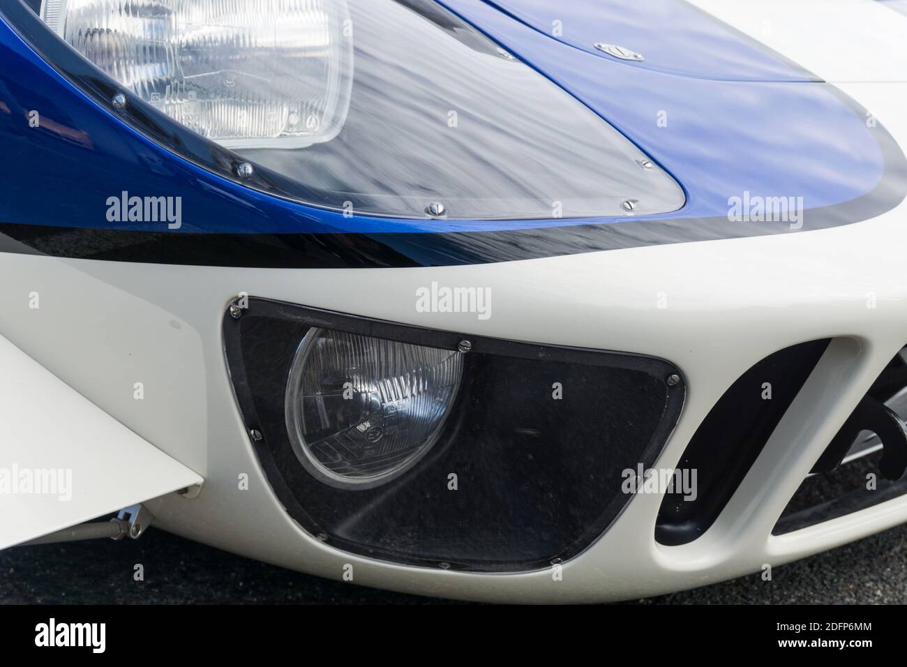 Close up detail of the headlight and spotlight of a metallic blue and ...