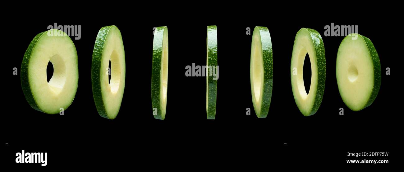 Avocado slices levitating in the air on black background Stock Photo