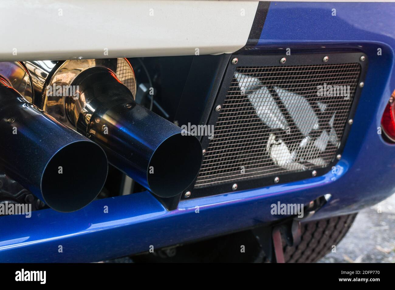 Close up detail of the exhaust pipes on a metallic blue and white