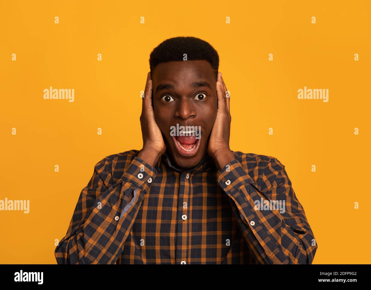 Portrait Of Shocked Funny Young Black Guy Clutching Head In Excitement Stock Photo