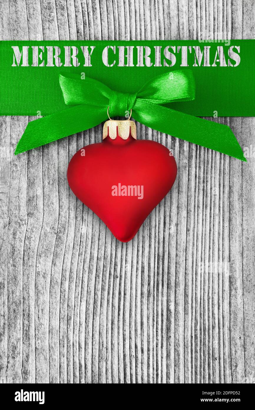 Red heart and Merry Christmas against wooden background Stock Photo
